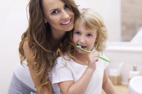 Mother teaches daughter to brush teeth — Stock Photo, Image