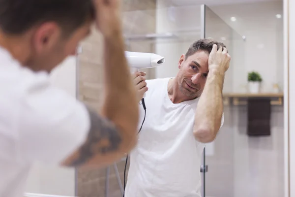 Mies kampaamassa hiuksiaan — kuvapankkivalokuva