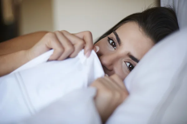 Молода сором'язлива жінка в ліжку — стокове фото