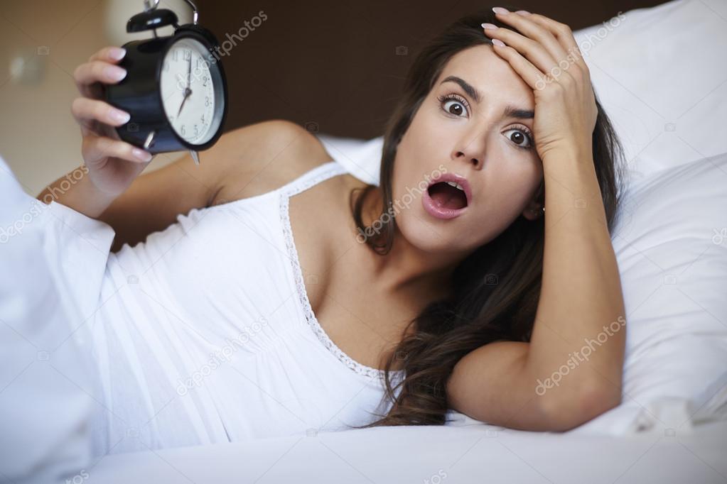 Woman in bed with alarm