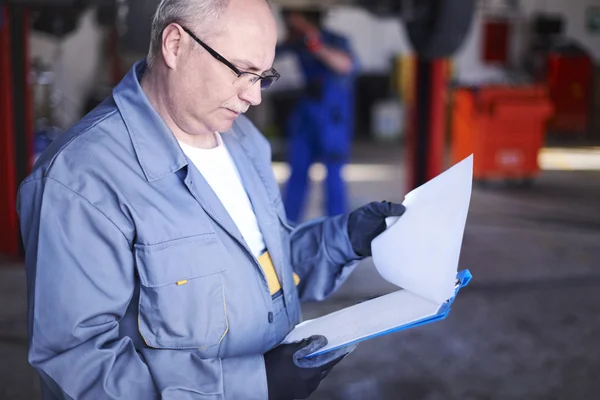 Mechanic checking orders — Stock Photo, Image