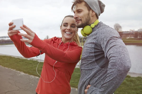 Sportliches Paar nutzt Smartphone — Stockfoto