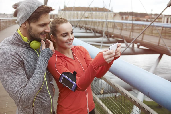 Sportliches Paar nutzt Smartphone — Stockfoto