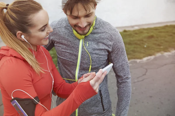 Couple sportif utilisant un smartphone — Photo