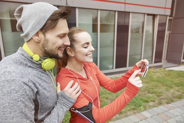 Casal desportivo usando smartphone — Fotografia de Stock