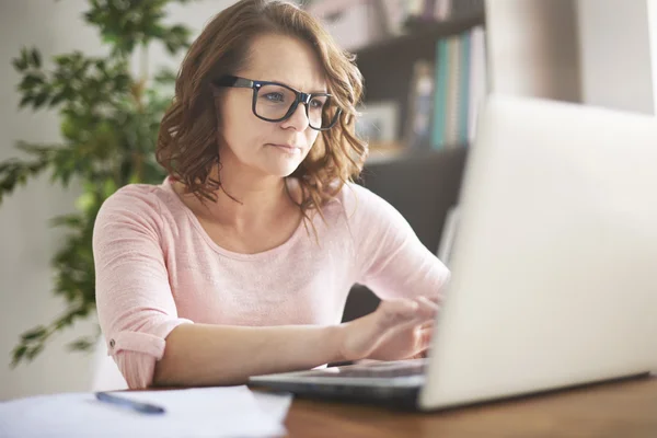 Mulher em óculos funciona no laptop . — Fotografia de Stock