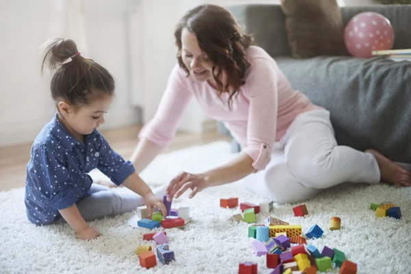 Happy mother with her daughter playing together. — Stock Photo, Image