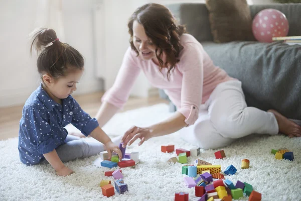 Glückliche Mutter mit ihrer Tochter beim gemeinsamen Spielen. — Stockfoto