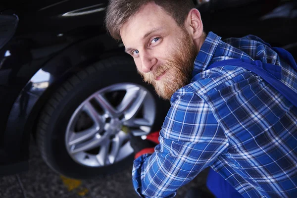 Mecánico de coche girando la rueda del coche — Foto de Stock