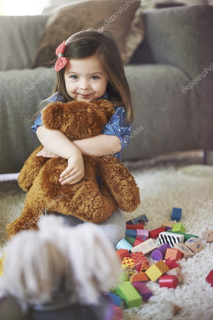 little girl hugging teddy bear