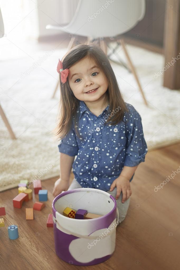 Cute small girl cleans up her room