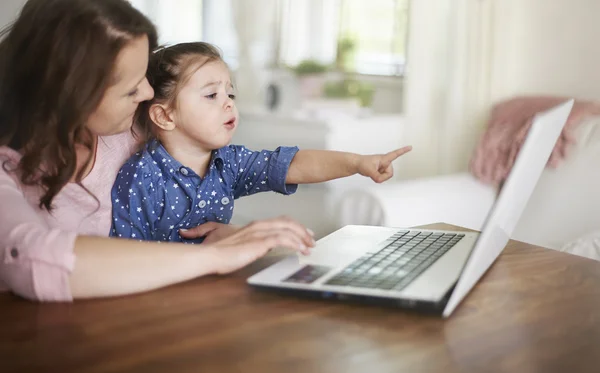 Dizüstü bilgisayar kullanan şirin kız annesiyle — Stok fotoğraf