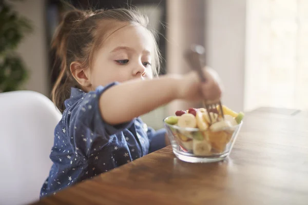 Little girl eats sweet fruits. — Stock Photo, Image