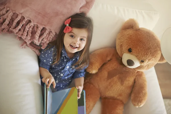 Chica con oso de peluche y leer libro — Foto de Stock