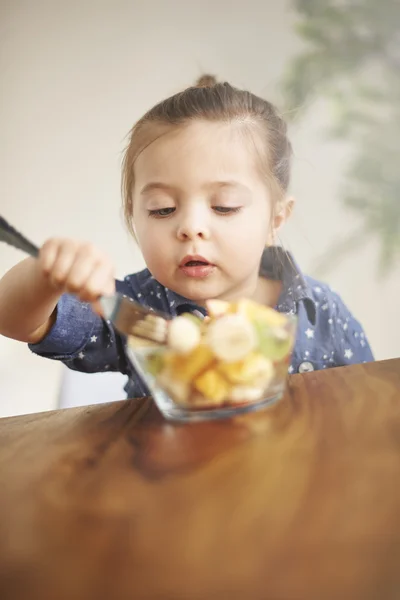 Liten flicka äter frukter — Stockfoto