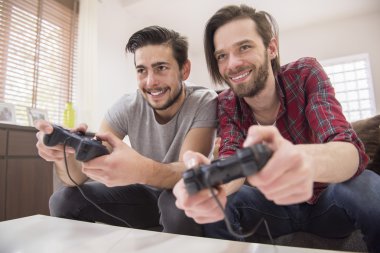 Men playing computer game together clipart