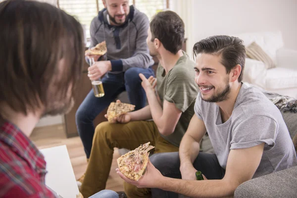 Men eating pizza and drinking a beer — Stock Photo, Image