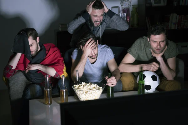 Грустные друзья смотрят футбольный матч — стоковое фото