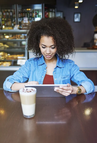 Fille boire du café et en utilisant une tablette numérique — Photo