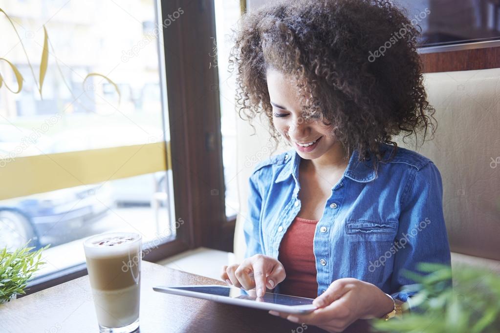 Girl using digital tablet in cafe