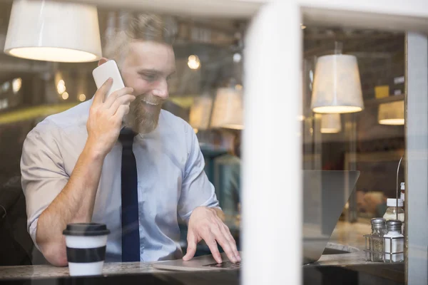 Successful businessman in cafe talking on phone — Stok fotoğraf