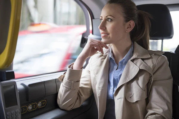 Successful businesswoman in cab — Stockfoto