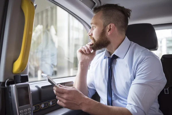 Successful business in cab with phone — Stock Photo, Image