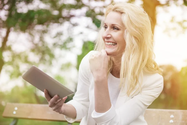Beautiful woman smiling with tablet — Stock Photo, Image