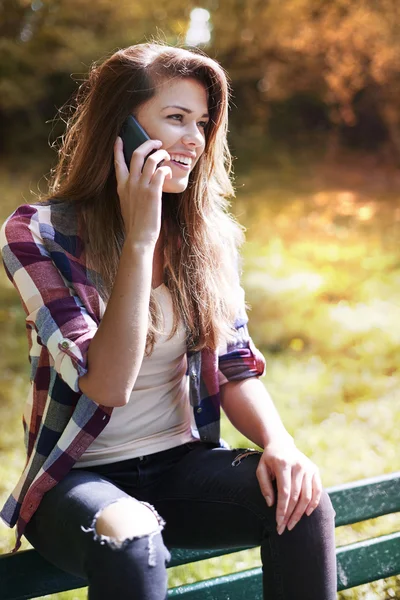 Frau im Park telefoniert — Stockfoto