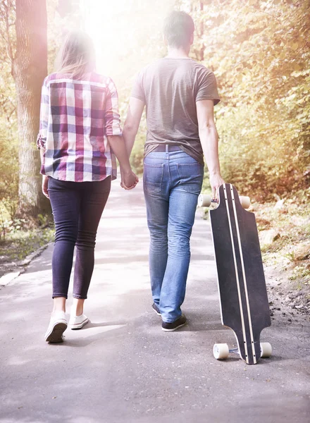 Paar in liefde lopen met skate — Stockfoto