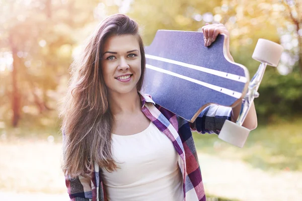 Kvinna anläggning skate på axel — Stockfoto