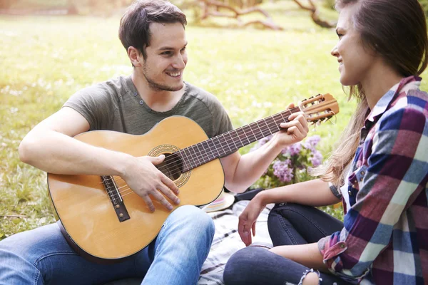 Hombre tocando la guitarra a su novia — Foto de Stock