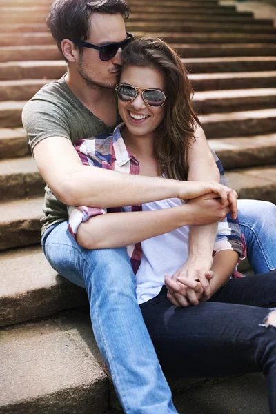 Paar verliefd zittend op trappen en glimlachen — Stockfoto
