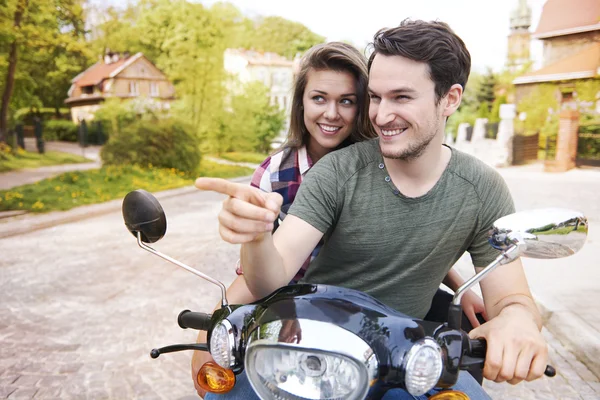 Couple in love riding bike and pointing way — Stock Photo, Image