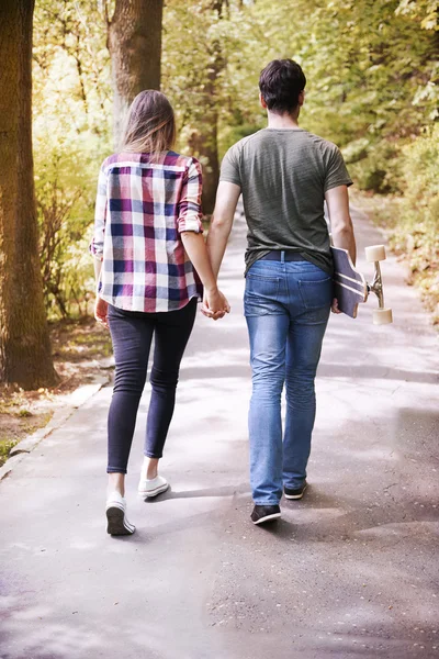 Coppia innamorata passeggiando nel parco, vista posteriore — Foto Stock