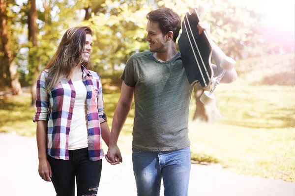 Young couple with skate in park — Stock Photo, Image