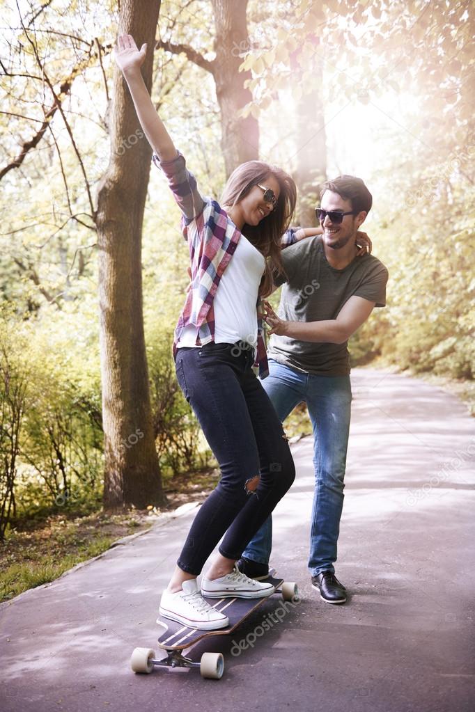 young couple skating in park