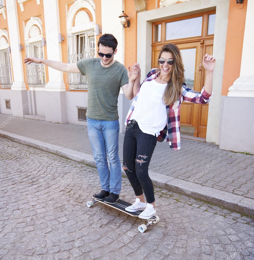 young couple riding skate in park