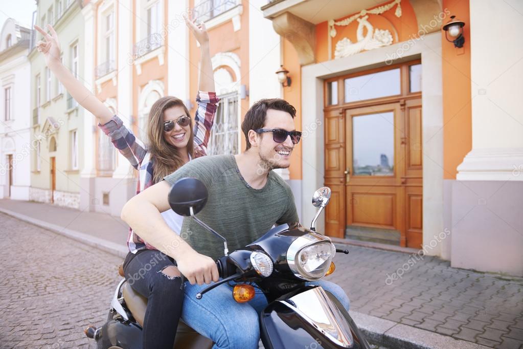 young couple riding bike in city