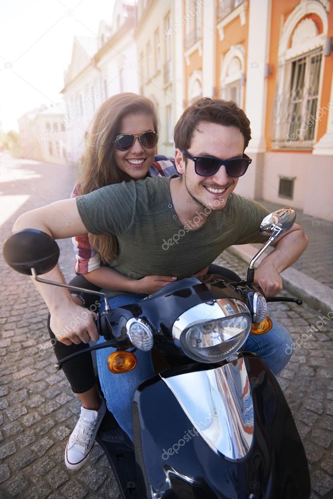 young couple riding bike in city