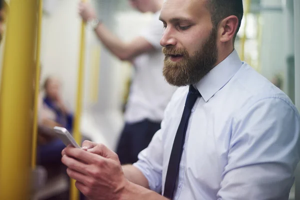 Biznesmen w metrze z telefonu — Zdjęcie stockowe