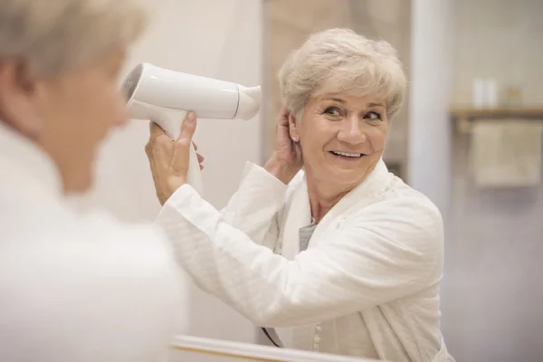 Volwassen vrouw haar haren drogen — Stockfoto