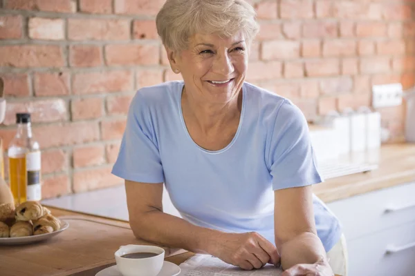 Mature smiling woman in kitchen — Stock Photo, Image