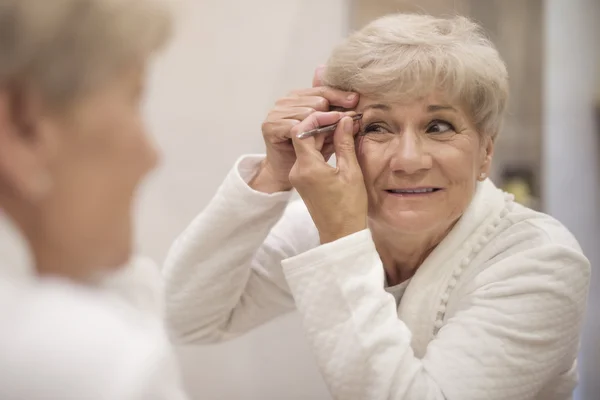 Зрелая женщина делает макияж — стоковое фото