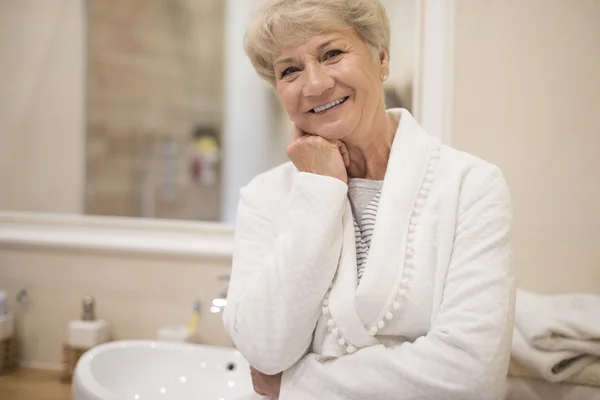 Volwassen vrouw in witte badjas — Stockfoto