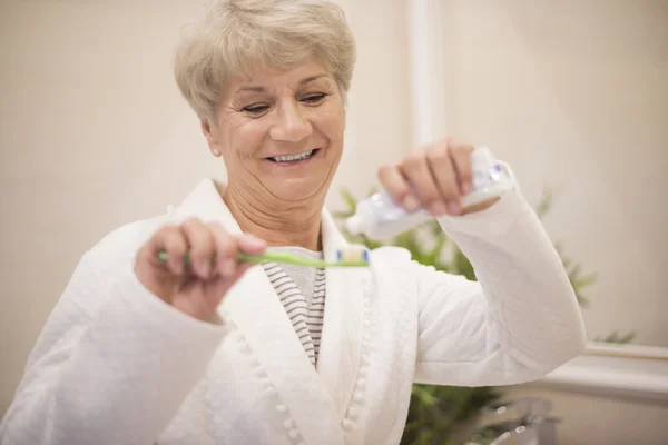 Senior woman using her toothbrush — Stock Photo, Image