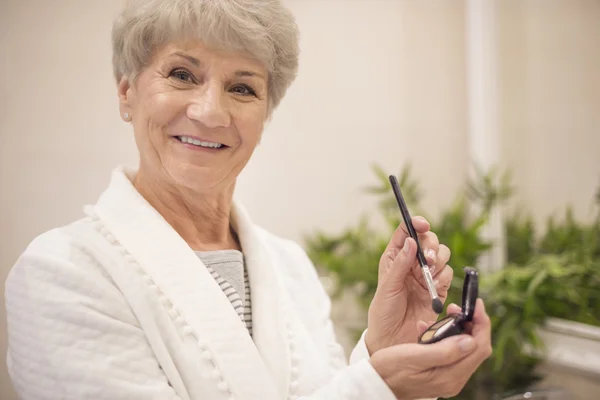 Mature woman doing make up — Stock Photo, Image