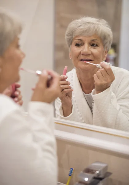 Mature woman doing make up — Stock Photo, Image