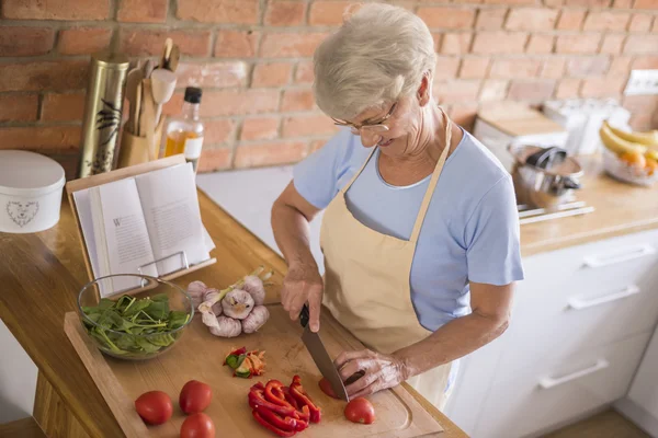 Mogen kvinna förbereder god mat — Stockfoto