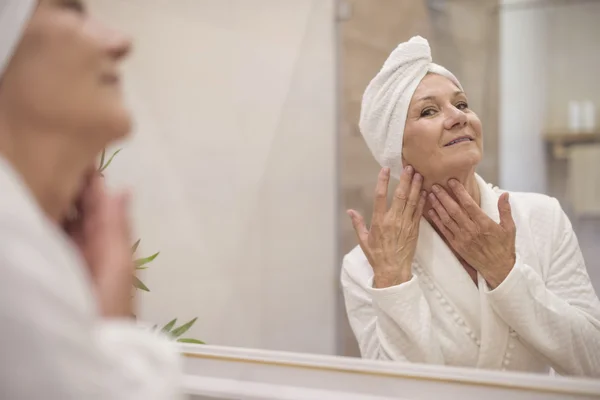 Mujer madura haciendo masaje facial — Foto de Stock